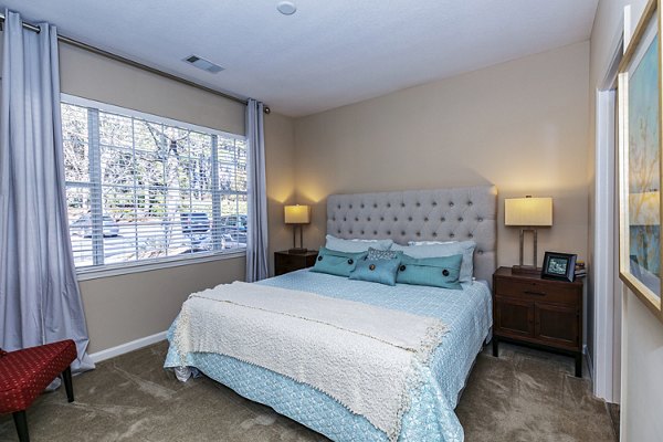 Elegant bedroom with cozy lighting and plush bedding at Andover at Johns Creek Apartments