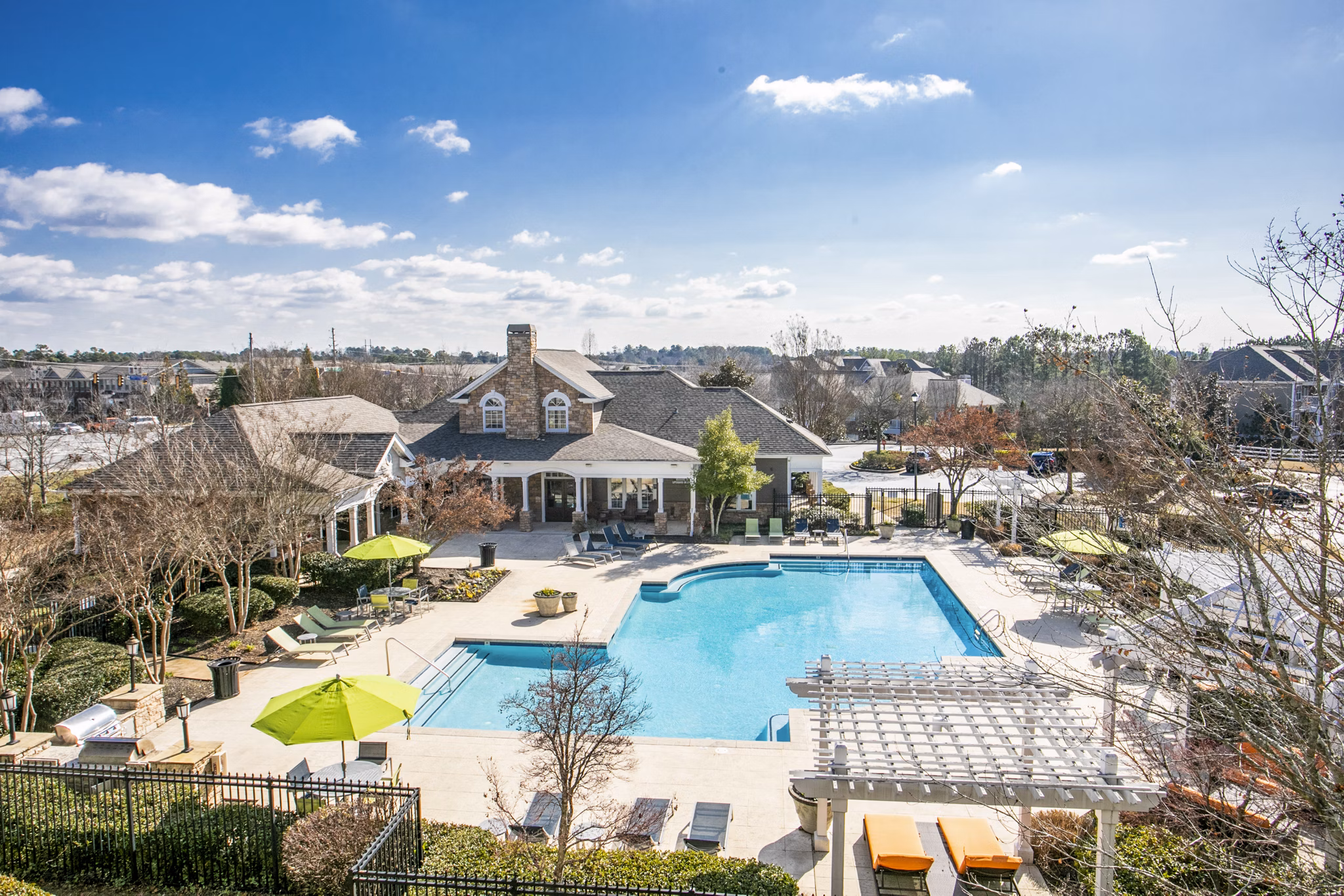 Poolside lounge area at Andover at Johns Creek Apartments with sun chairs and greenery Enjoy leisure and relaxation in this inviting outdoor space