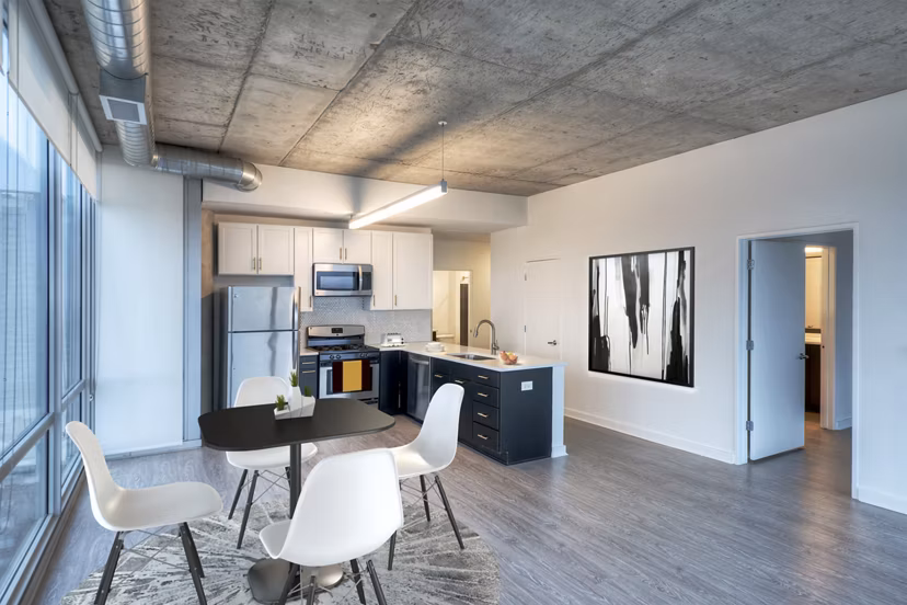 Dining room featuring elegant wooden furniture and modern lighting at 1401 S State Apartments, a luxury living space by Greystar