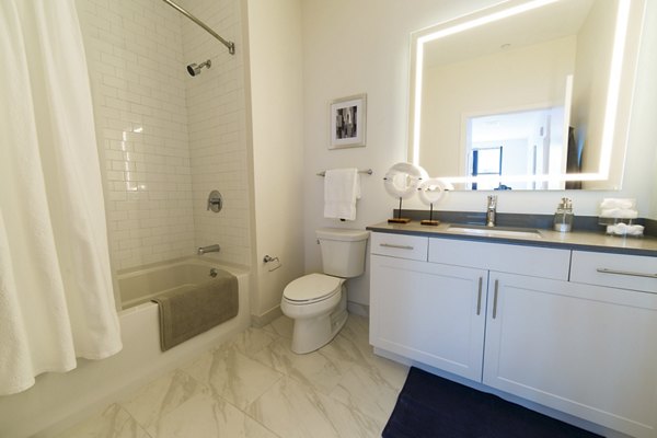 Modern bathroom featuring sleek fixtures and a large mirror in Montaje Apartments