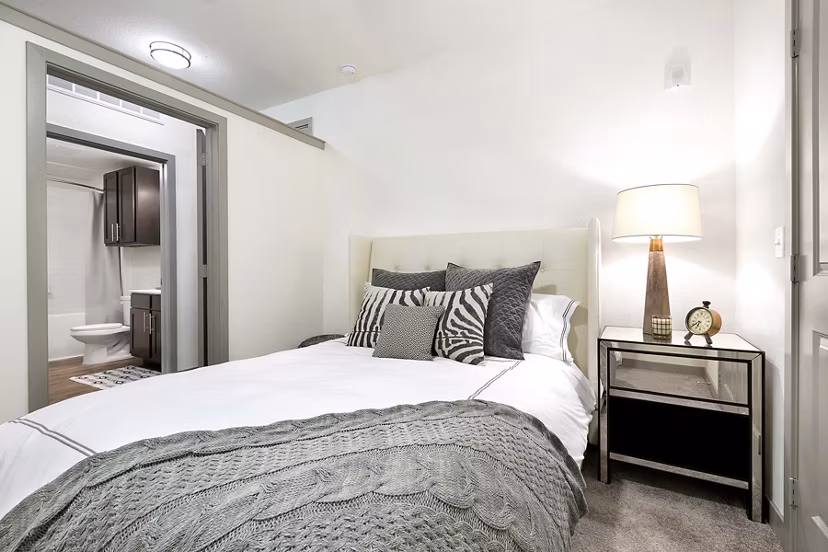 Cozy bedroom with modern furnishings and ample natural light at West Koenig Flats Apartments
