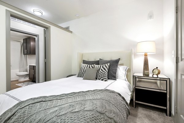 Cozy bedroom with modern furnishings and ample natural light at West Koenig Flats Apartments