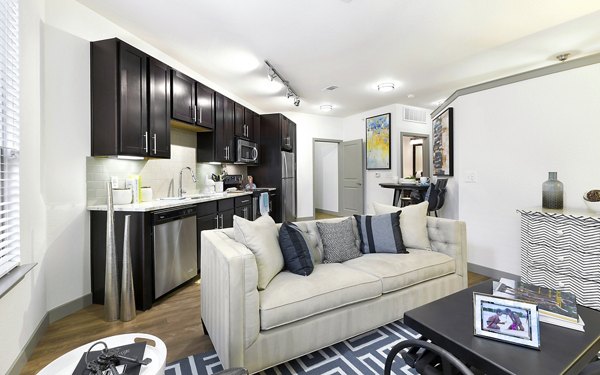 Spacious living room with modern decor in West Koenig Flats Apartments