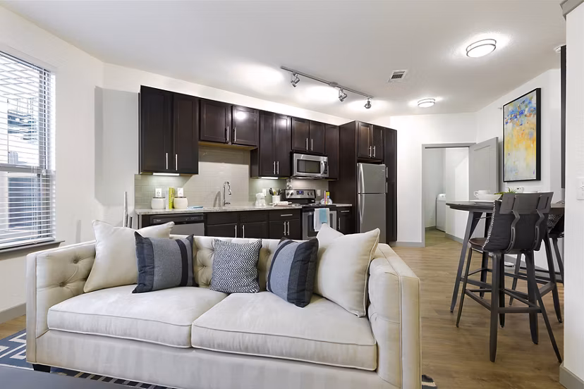 Spacious living room with modern decor and natural light in West Koenig Flats Apartments, ideal for relaxing and entertaining