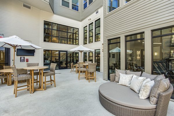 Outdoor lounging area with modern seating and greenery at West Koenig Flats Apartments