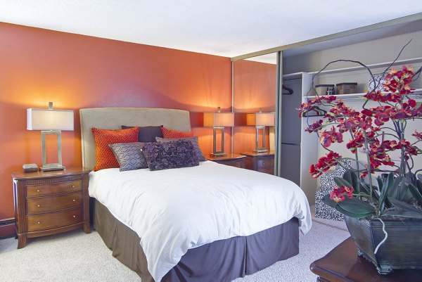 Contemporary bedroom with orange accent wall and stylish decor at Summit Ridge Apartments