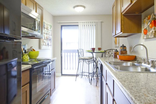 Summit Ridge Apartments: Bright kitchen with stainless steel appliances and cozy dining area in Greystar luxury apartments