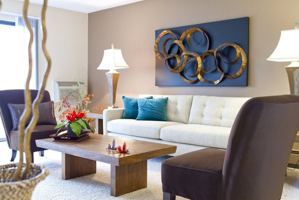 Bright living room with abstract wall art and cozy seating at Summit Ridge Apartments, a luxury property managed by Greystar