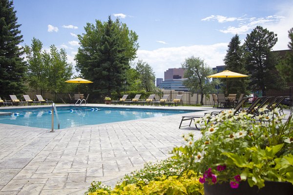 Relaxing outdoor pool area with yellow umbrellas and lounge chairs at Summit Ridge Apartments, perfect for leisure and luxury living