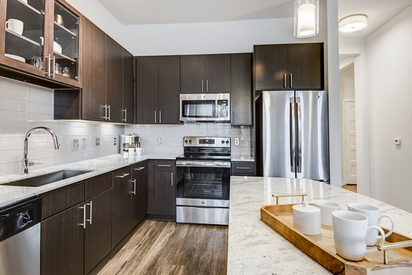 Modern kitchen with stainless steel appliances and granite countertops at Overture Stone Oak luxury apartments