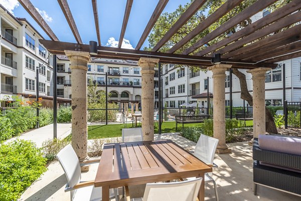 Outdoor grill area with seating at Overture Stone Oak luxury apartments in San Antonio