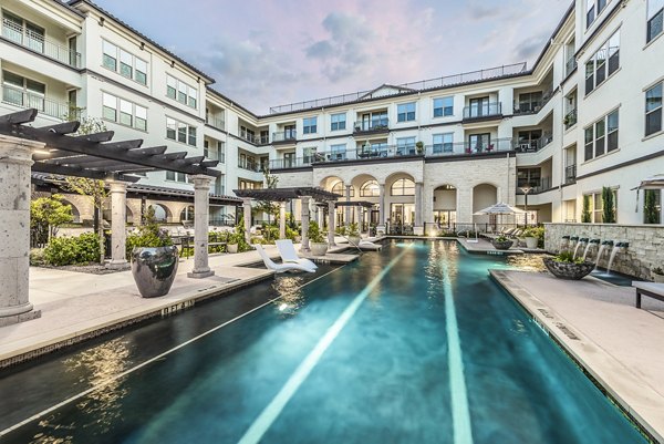 Relaxing poolside retreat at Overture Stone Oak apartments, complete with stylish loungers and water features