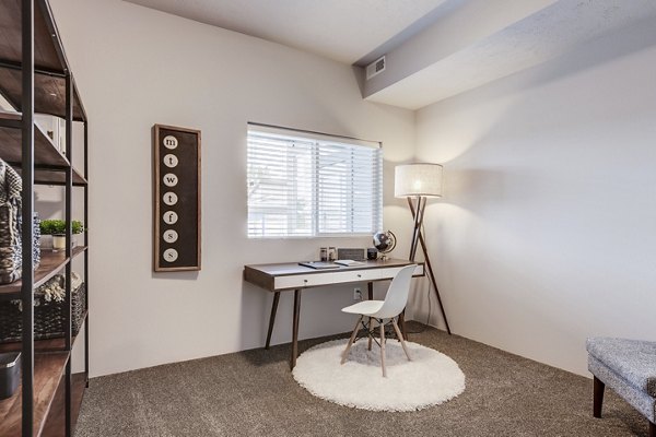 Cozy bedroom with modern decor at Bella Tess Apartments, featuring plush carpeting and large windows for natural light