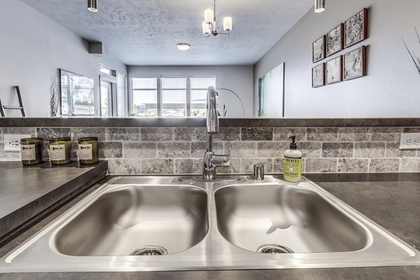 Kitchen featuring modern appliances and granite countertops at Bella Tess Apartments