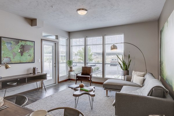 Stylish living room with modern furnishings at Bella Tess Apartments, featuring a comfortable seating area and contemporary design