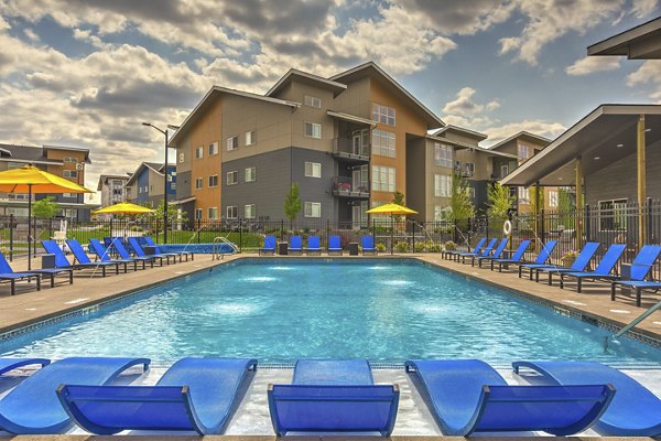 Resort-style swimming pool at Bella Tess Apartments with luxury seating and landscaped surroundings