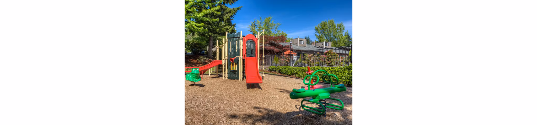 Playground at Onyx Apartments featuring colorful slides and swings, perfect for family fun in a community setting