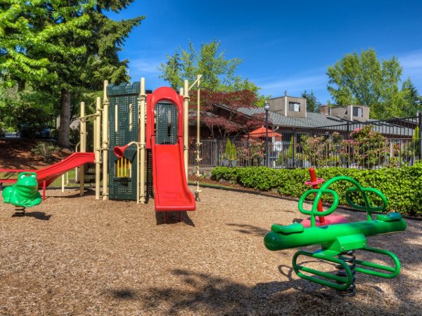 Playground at Onyx Apartments featuring colorful slides and swings, perfect for family fun in a community setting