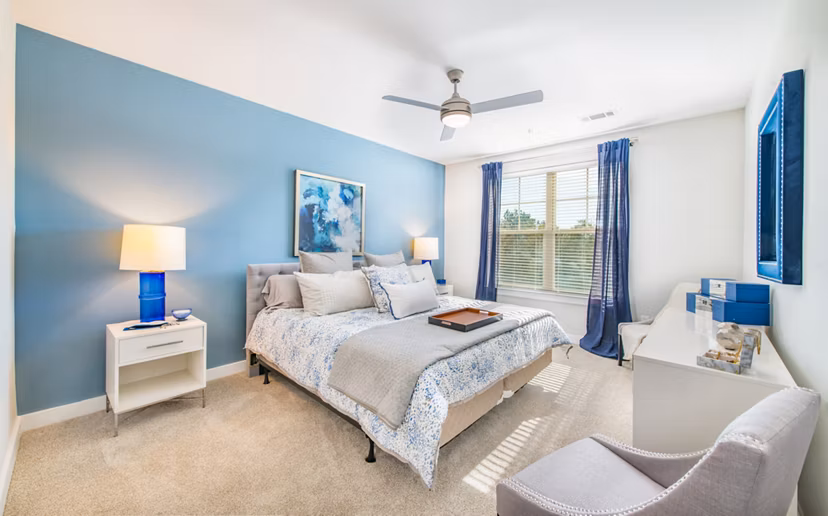 Bedroom with elegant decor and large windows at Overture Crabtree Apartments