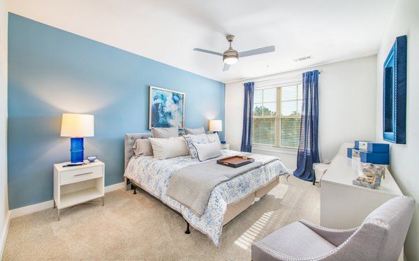 Bedroom with elegant decor and large windows at Overture Crabtree Apartments