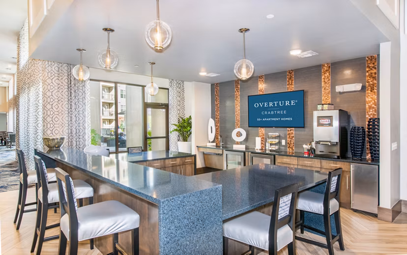 Clubhouse featuring modern lounge areas and seating at Overture Crabtree Apartments