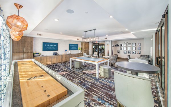 Game room with billiards and lounge seating at Overture Crabtree Apartments