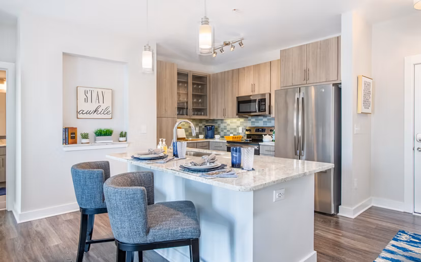 Modern kitchen with stainless steel appliances and granite countertops at Overture Crabtree Apartments in Raleigh