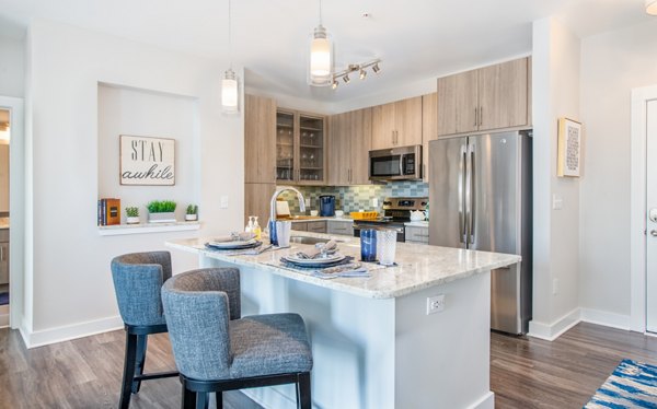 Modern kitchen with stainless steel appliances and granite countertops at Overture Crabtree Apartments in Raleigh