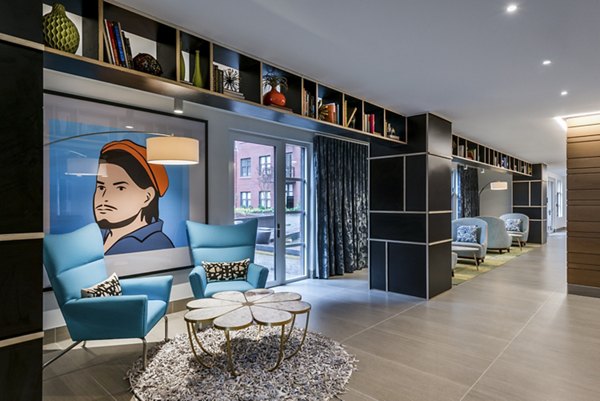 Modern living room with blue chairs, round coffee table, and large artwork in luxury apartments