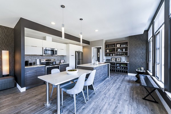 Modern kitchen and dining area featuring sleek appliances and a stylish table in luxury apartments