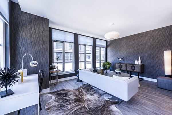 Modern living room with a white sofa and large windows in luxury apartments