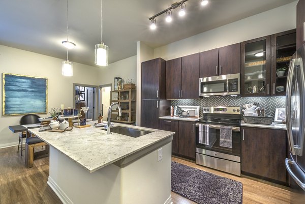 Modern kitchen featuring stainless steel appliances and quartz countertops at Overture Fairview Apartments