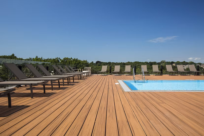 Serene outdoor pool area surrounded by lush greenery at Serenity Apartments