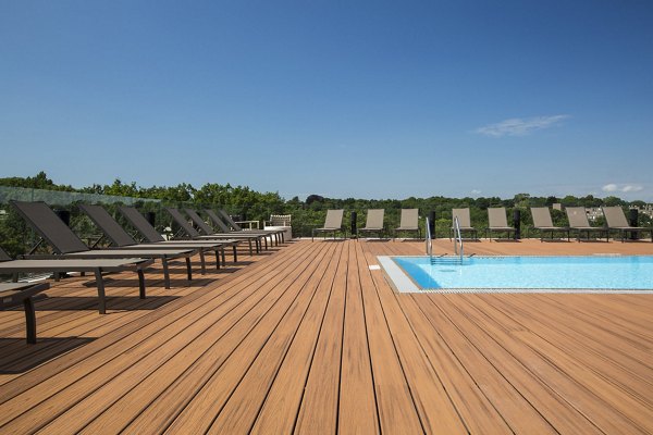 Serene outdoor pool area surrounded by lush greenery at Serenity Apartments