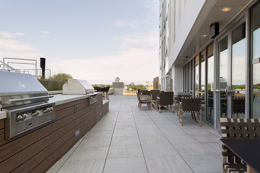 Outdoor grill area with modern seating at Serenity Apartments, offering luxury community spaces for residents