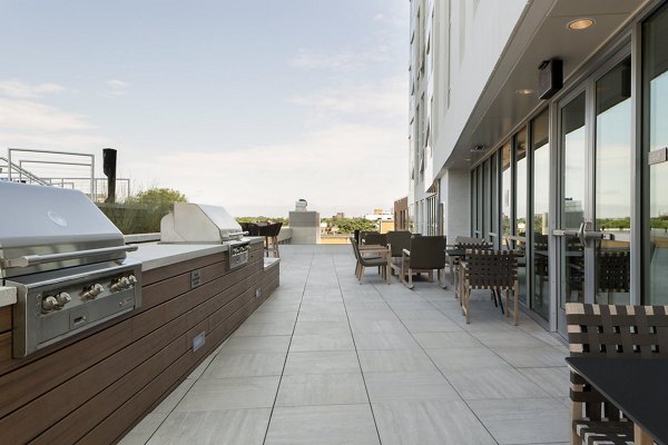 Outdoor grill area with modern seating at Serenity Apartments, offering luxury community spaces for residents