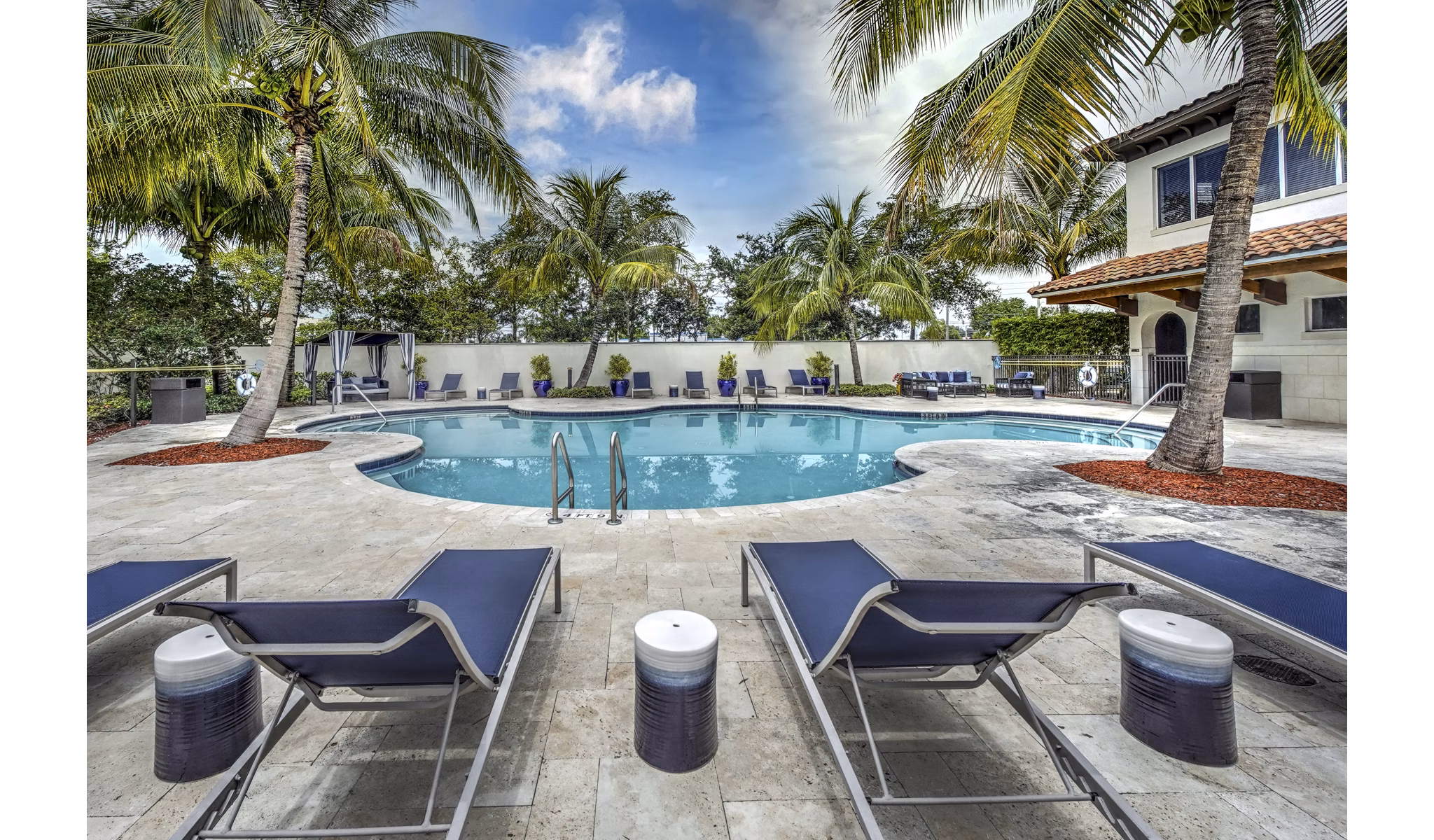 Resort-style pool with palm trees and lounge chairs at Solle Davie Luxury Apartments