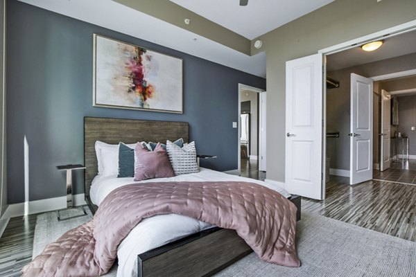 Modern bedroom with city views at Ascent Uptown Apartments