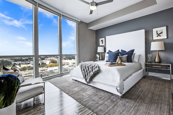Modern bedroom with plush bedding and city views at Ascent Uptown Apartments