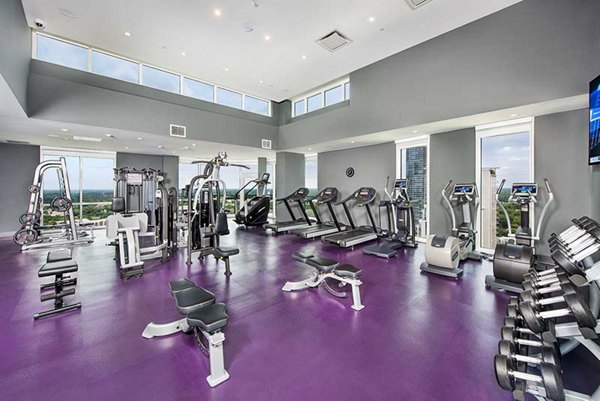 Modern fitness center with high-tech equipment at Ascent Uptown Apartments