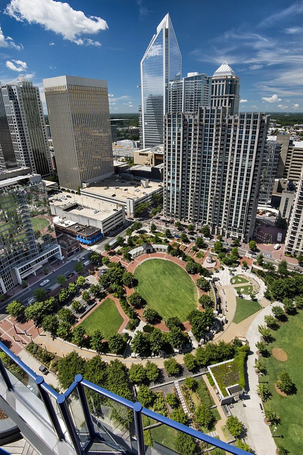 Scenic rooftop deck with modern seating at Ascent Uptown Apartments, offering city skyline views