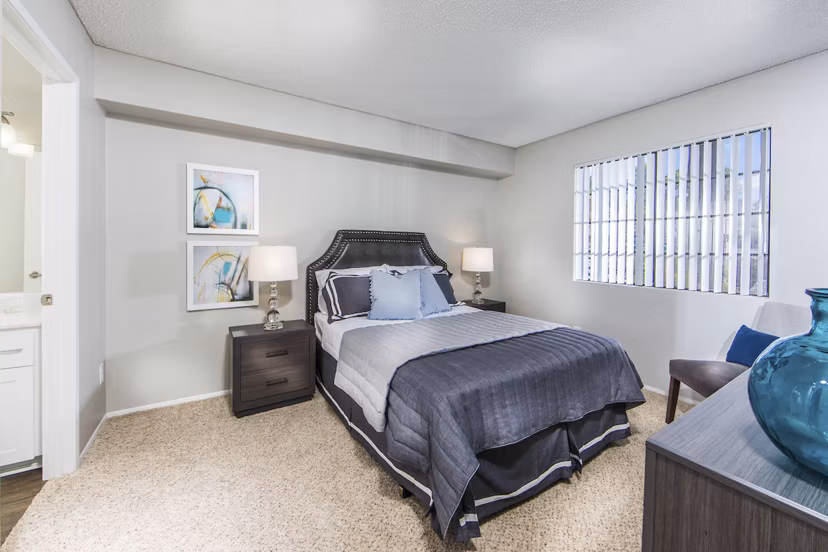 Bedroom at Hacienda Vallecitos Apartments featuring elegant design and cozy furnishings