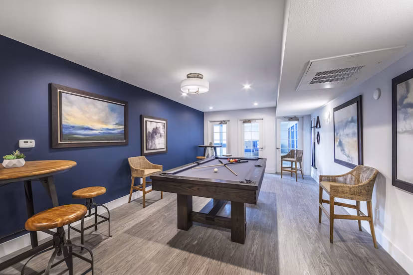 Game room with billiards table and lounge seating at Overture San Marcos Apartment Homes