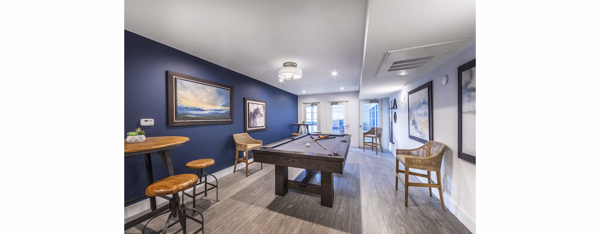 Game room with billiards table and lounge seating at Overture San Marcos Apartment Homes