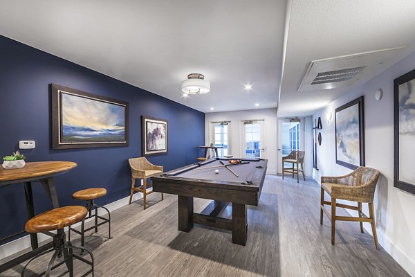Game room with billiards table and lounge seating at Overture San Marcos Apartment Homes
