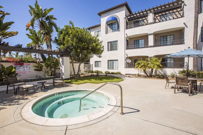 Relaxing hot tub at Hacienda Vallecitos Apartments surrounded by lush greenery