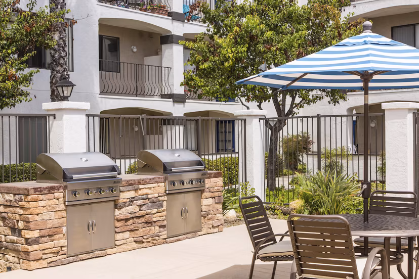 Grill area with outdoor seating at Hacienda Vallecitos Apartments