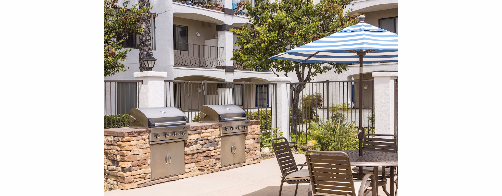 Grill area with outdoor seating at Hacienda Vallecitos Apartments
