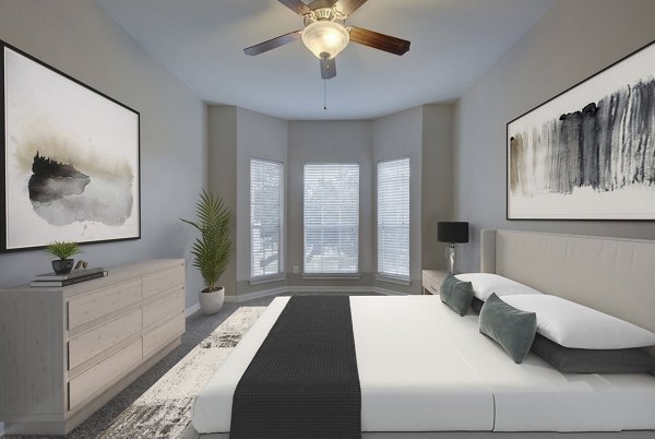 Sunlit bedroom with contemporary decor at Parc at Wall Street Apartments featuring plush bedding and modern furnishings