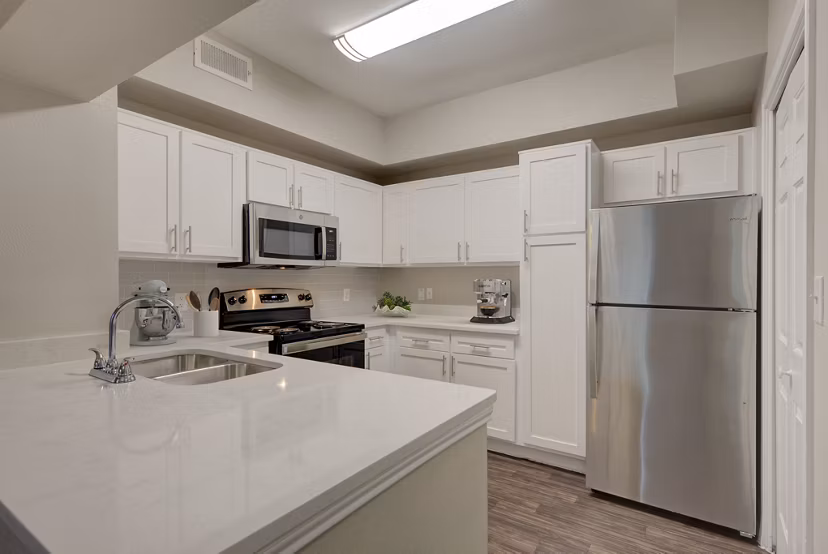 Modern kitchen with stainless steel appliances at Parc at Wall Street Apartments